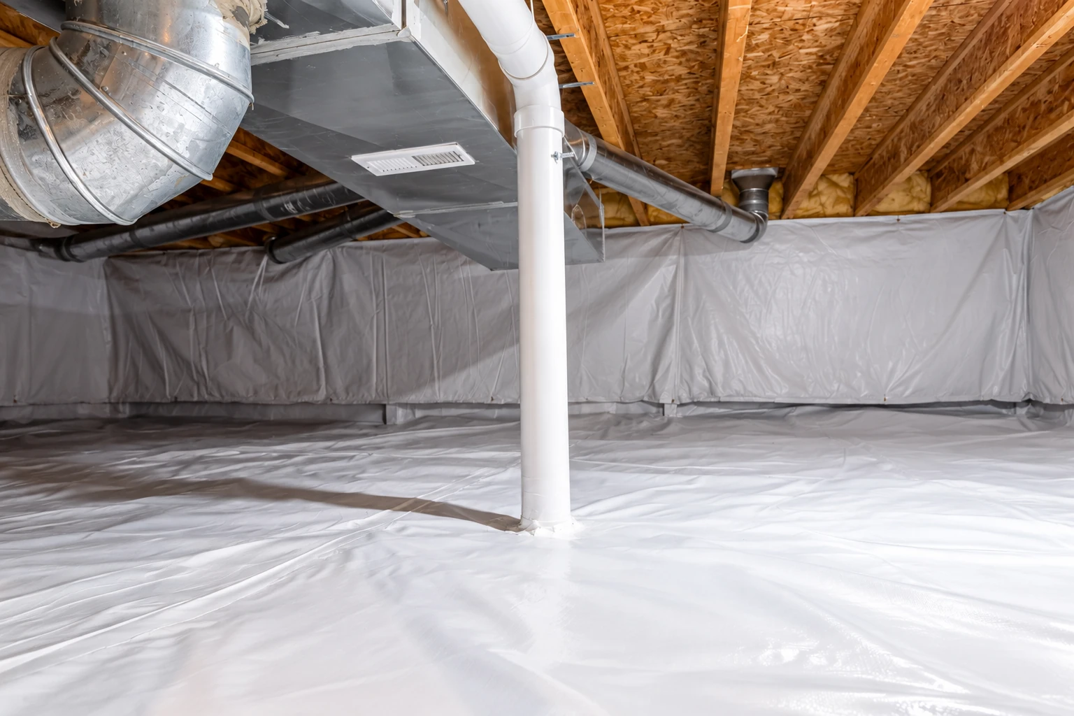 A crawl space has white plastic sheeting over the floor and walls, with ductwork and a white pipe overhead.